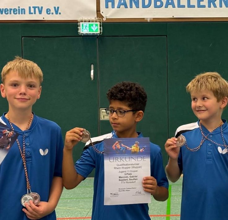 Gruppe junger Tischtennisspieler in blauen Т-Shirts vor einem Vereinshaus.