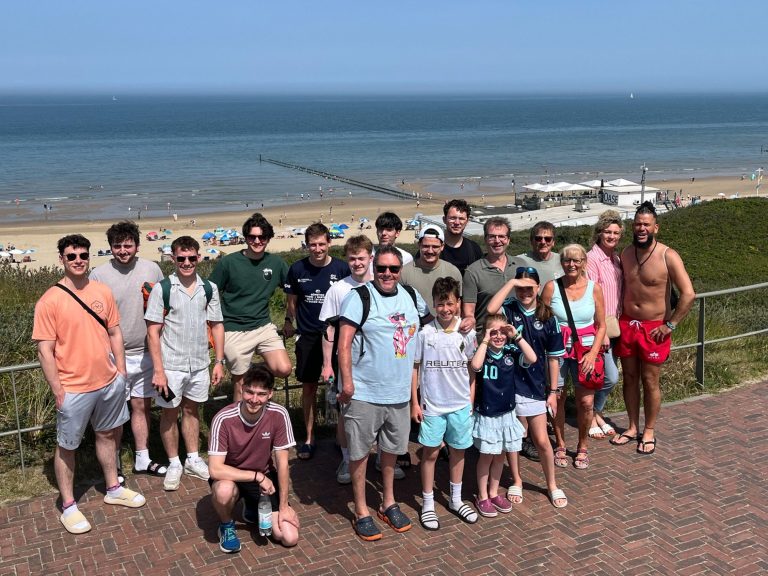 Gruppe junger Tischtennisspieler in blauen Т-Shirts vor einem Vereinshaus. Gruppe junger Tischtennisspieler in blauen Т-Shirts vor einem Vereinshaus.
