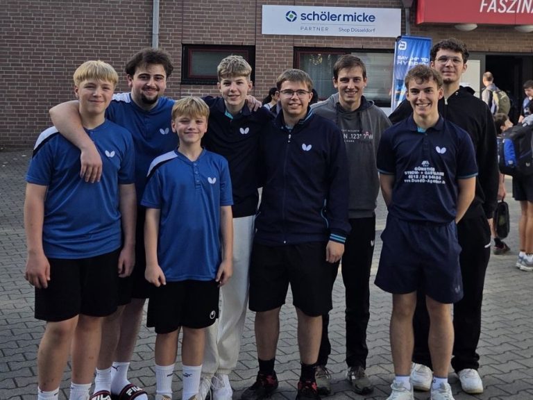 Gruppe junger Tischtennisspieler in blauen Т-Shirts vor einem Vereinshaus.