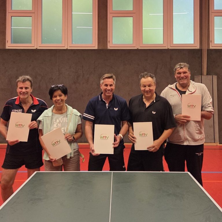 Gruppe junger Tischtennisspieler in blauen Т-Shirts vor einem Vereinshaus.