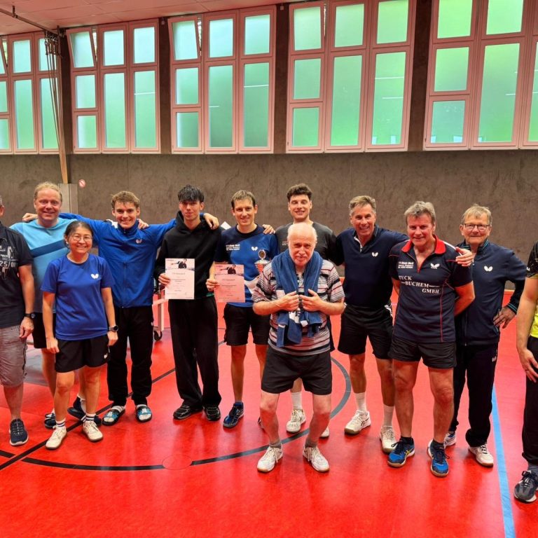 Gruppe junger Tischtennisspieler in blauen Т-Shirts vor einem Vereinshaus.