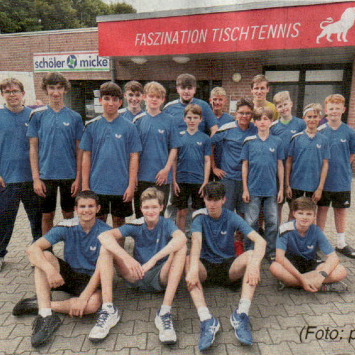 Gruppe junger Tischtennisspieler in blauen Т-Shirts vor einem Vereinshaus.